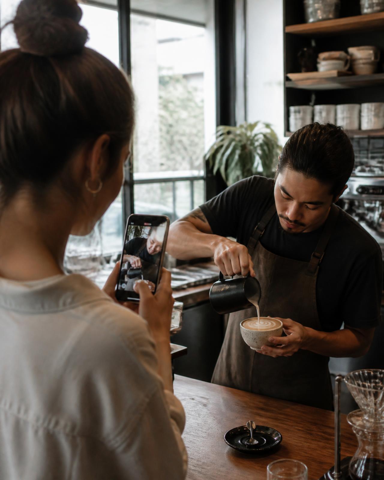 Local creator filming a barista pouring latte art
